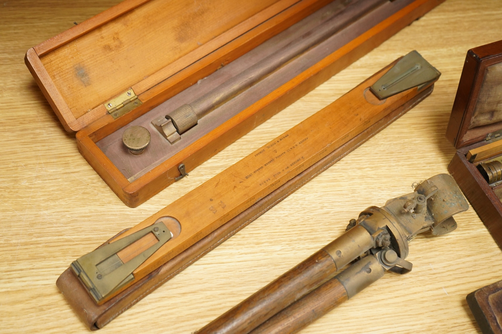 Five scientific instruments, comprising; a rolling parallel rule, pine boxed, 48cm wide; an early 20th century boxwood and brass Alidade, by J. Hicks, 8, 9 & 10, Hatton Garden, leather cased; an oak and brass tripod, sta